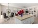 Open concept kitchen and dining area with island, custom shelving, and stainless steel appliances at 15936 W Clear Canyon Dr, Surprise, AZ 85374