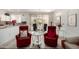 Bright living space featuring tiled floors, red chairs, and glass table, perfect for entertaining at 15936 W Clear Canyon Dr, Surprise, AZ 85374