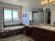 Bathroom view showing a bathtub, large window, decorative tile, and and sink at 16401 S 29Th Dr, Phoenix, AZ 85045