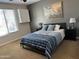 Comfortable bedroom with a ceiling fan, natural light, and modern decor at 16401 S 29Th Dr, Phoenix, AZ 85045