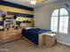 Comfortable bedroom with wood furniture, large windows with plantation shutters, and eye-catching wall stripes at 16401 S 29Th Dr, Phoenix, AZ 85045
