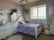 Charming bedroom features a decorative floral wall, ceiling fan, and bright natural light at 16401 S 29Th Dr, Phoenix, AZ 85045