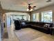 Large living room area featuring modern ceiling fan, stone fireplace, and backyard access at 16401 S 29Th Dr, Phoenix, AZ 85045