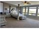 Spacious main bedroom featuring a four-poster bed, dresser, and large windows with scenic views at 16401 S 29Th Dr, Phoenix, AZ 85045