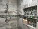 Beautiful shower with gray tile and a decorative tiled niche with toiletries at 16401 S 29Th Dr, Phoenix, AZ 85045