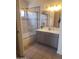 Updated bathroom featuring a glass-enclosed shower, tiled walls, and a modern vanity with dual sinks at 1705 E Juanita Ave, Mesa, AZ 85204