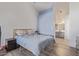 Bright bedroom with a soft blue accent wall, a cozy bed, and an en-suite bathroom with modern fixtures at 1705 E Juanita Ave, Mesa, AZ 85204