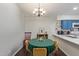 Dining area with a chandelier and seating for four, adjacent to kitchen with blue cabinets at 1705 E Juanita Ave, Mesa, AZ 85204