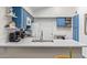 Bright kitchen featuring white marble countertops, stainless steel sink, and blue cabinetry at 1705 E Juanita Ave, Mesa, AZ 85204