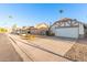 A residential street view showcasing well-maintained single-Gathering homes, complemented by lush greenery and clear blue skies at 1705 E Juanita Ave, Mesa, AZ 85204