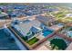 Aerial view of a home with a pool, covered patio, landscaped yard, and surrounding neighborhood at 17962 W Elm St, Goodyear, AZ 85395