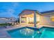 Lovely backyard showcasing a pool, covered patio with a firepit, an outdoor seating and lush green grass at 17962 W Elm St, Goodyear, AZ 85395