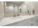 Bright bathroom with double sink vanity, white cabinets, quartz countertops, and decorative mosaic backsplash at 17962 W Elm St, Goodyear, AZ 85395