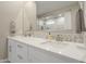 Bathroom featuring a double sink vanity with white cabinetry, quartz countertop and decorative backsplash tiles at 17962 W Elm St, Goodyear, AZ 85395