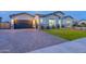 Charming home exterior with a dark garage door, manicured lawn, and a paved driveway at 17962 W Elm St, Goodyear, AZ 85395