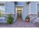 Elegant front entrance featuring a decorative door, stone accents, and vibrant landscaping at 17962 W Elm St, Goodyear, AZ 85395