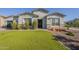 Well-maintained home featuring a lush green lawn and stone accents at the front exterior at 17962 W Elm St, Goodyear, AZ 85395
