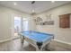 Bright game room features a pool table, decor, and French doors to the outdoors at 17962 W Elm St, Goodyear, AZ 85395