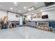 Clean garage featuring epoxy floors, gray cabinets, a work bench, and a mounted television at 17962 W Elm St, Goodyear, AZ 85395