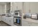 Gourmet kitchen featuring white cabinets, stainless steel appliances, and tiled backsplash at 17962 W Elm St, Goodyear, AZ 85395