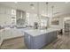 Open kitchen with island, pendant lighting, quartz counters, and stainless steel appliances at 17962 W Elm St, Goodyear, AZ 85395