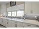 Bright kitchen featuring white cabinets, quartz countertops, and ample natural light at 17962 W Elm St, Goodyear, AZ 85395