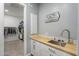 Functional laundry room boasts a butcher block countertop, cabinetry and decor for added convenience at 17962 W Elm St, Goodyear, AZ 85395