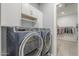 Laundry area features a modern washer and dryer, with storage cabinets and nearby walk-in closet access at 17962 W Elm St, Goodyear, AZ 85395