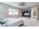 View of the main bedroom with a ceiling fan, furniture, a television and access to an adjacent room at 17962 W Elm St, Goodyear, AZ 85395