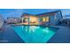Inviting backyard with a sparkling pool reflecting the twilight sky, and comfortable lounge chairs for relaxing at 17962 W Elm St, Goodyear, AZ 85395