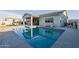 Refreshing pool reflecting the house with an open patio and lounging furniture at 17962 W Elm St, Goodyear, AZ 85395