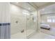 Large glass enclosed shower with rainfall shower head, built in niche, and mosaic tile accent at 17962 W Elm St, Goodyear, AZ 85395