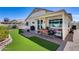 Beautiful backyard featuring a covered patio, artificial grass, and well-manicured landscaping perfect for outdoor entertaining at 17988 W Deneen Way, Surprise, AZ 85374