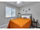 Cozy bedroom with neutral walls, ceiling fan, window with blinds, and a comfortable bed with orange quilt at 17988 W Deneen Way, Surprise, AZ 85374