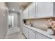 Hallway featuring built-in white cabinets and drawers with hardware and decor, leading to a bathroom at 17988 W Deneen Way, Surprise, AZ 85374