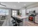 Bright kitchen featuring a large island with seating, stainless steel appliances, and sliding glass doors leading to the patio at 17988 W Deneen Way, Surprise, AZ 85374