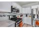 Modern kitchen boasting stainless steel appliances, sleek countertops, white cabinets, and stylish backsplash at 17988 W Deneen Way, Surprise, AZ 85374