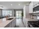 Open concept kitchen featuring white cabinets, stainless steel appliances, quartz countertops, and access to the backyard at 17988 W Deneen Way, Surprise, AZ 85374