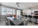 Sunlit kitchen and dining area features sliding glass doors and barstool seating at 17988 W Deneen Way, Surprise, AZ 85374