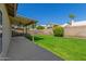 A well-maintained backyard features lush green grass, a covered patio, and a privacy wall for outdoor enjoyment at 1946 E Kings Ave, Phoenix, AZ 85022