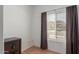 Minimalist bedroom, showing blinds, dark curtains, and a safe on the floor at 1946 E Kings Ave, Phoenix, AZ 85022