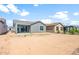 Backyard view showcasing the home's exterior, including sliding glass doors, windows, and landscaping potential at 21292 N 270Th Dr, Buckeye, AZ 85396