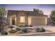 Inviting single-story home featuring a stone facade, neutral color palette, and a well-maintained desert landscape at 21292 N 270Th Dr, Buckeye, AZ 85396
