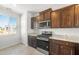 Stylish kitchen showcasing stainless steel appliances, granite countertops, dark wood cabinetry, and a bright window at 21292 N 270Th Dr, Buckeye, AZ 85396
