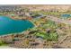 Aerial view of a resort-style community featuring a lake, putting green, clubhouse, and manicured landscaping at 24270 N 173Rd Ave, Surprise, AZ 85387