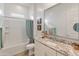 Well-lit bathroom with a granite countertop, bathtub with shower, and modern fixtures at 24270 N 173Rd Ave, Surprise, AZ 85387