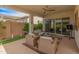 Inviting covered patio boasts a ceiling fan, comfortable seating, and sliding glass doors for seamless indoor-outdoor living at 24270 N 173Rd Ave, Surprise, AZ 85387