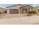 Inviting single-story home with stone accents, a charming front porch, and meticulously landscaped front yard at 24270 N 173Rd Ave, Surprise, AZ 85387