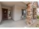 Charming covered front porch with stone pillars and cozy seating area; the perfect spot to relax and enjoy at 24270 N 173Rd Ave, Surprise, AZ 85387