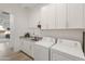 Convenient laundry room with granite countertops, cabinets, and modern appliances at 24270 N 173Rd Ave, Surprise, AZ 85387